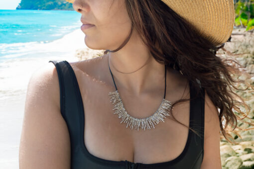 limu firecracker necklace on model/beach